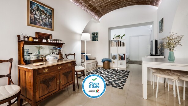 A spacious living room with a wooden cabinet, a sofa, a dining area with a TV, and a bookshelf.