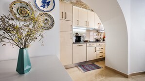 A modern kitchen with light-colored cabinets, a microwave, and a coffee maker.