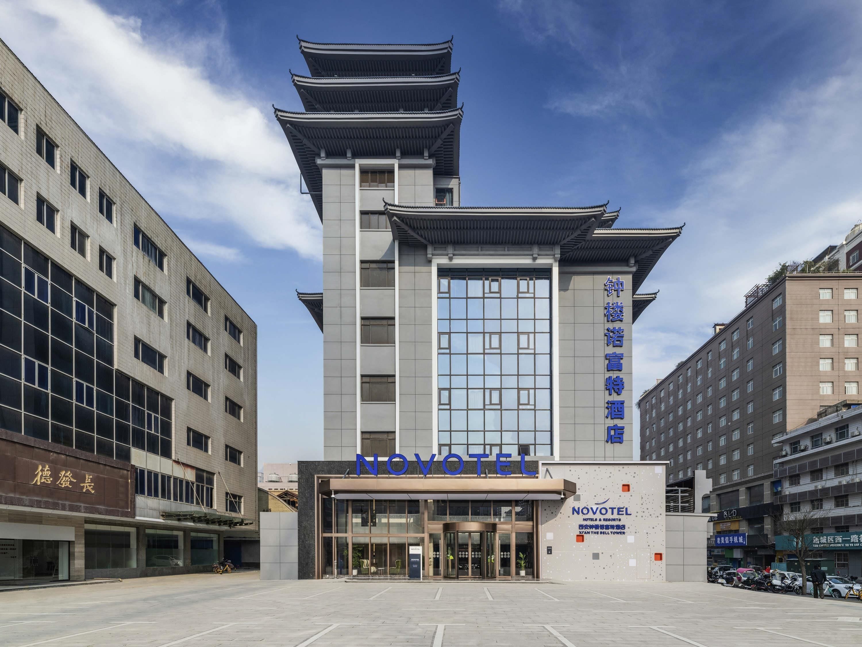 A hotel with a traditional architectural style, featuring a prominent tower and a modern entrance.
