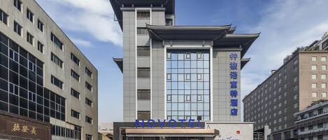 A hotel with a traditional architectural style, featuring a prominent tower and a modern entrance.