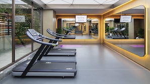 A modern gym with treadmills, mirrored walls, and a geometric ceiling design. - Novotel Xi'an The Bell Tower (Xi'an)