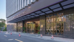 A modern hotel entrance with a glass facade, a covered entrance, and a geometric pattern on the windows. - Mercure Hangzhou East Railway Station (Hangzhou)