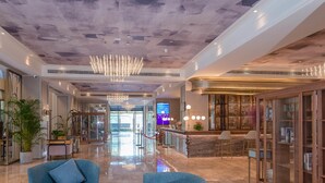 A spacious lobby with a high ceiling, a central chandelier, and a reception desk with a glass enclosure. - Mercure Hangzhou East Railway Station (Hangzhou)