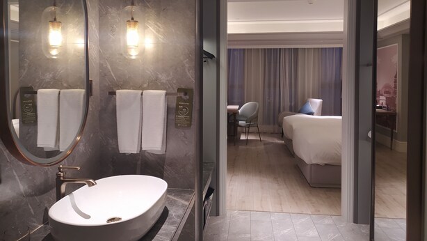 A modern bathroom with a large oval sink, a mirror, and two wall-mounted lights. - Mercure Hangzhou East Railway Station (Hangzhou)