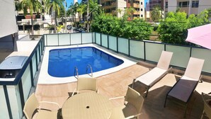 A rooftop pool area with a hot tub, lounge chairs, and a table. - Vacanze - Golden Place 503 (Maceió)