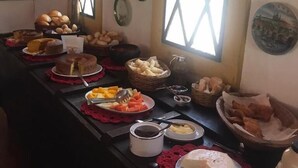 Una mesa de buffet con diversos alimentos y platos decorativos en la pared.
