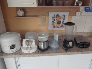 A kitchen counter with various appliances including a blender, a food processor, and a rice cooker. - Wonderful farm in the city of Peruibe with swimming pool, wifi, smart TV (Boungaiville)