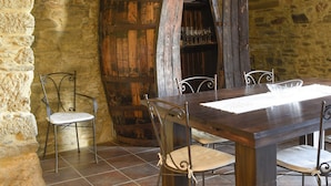 A rustic dining area with a wooden table and metal chairs, a stone wall, and a barrel. - Holiday Villa in Douro Valley - Unesco Heritage (Peso da Régua)