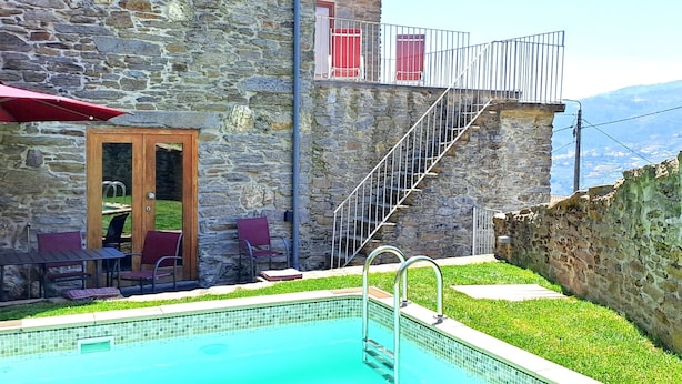 A stone building with a pool, outdoor seating, and a staircase leading to a balcony. - Holiday Villa in Douro Valley - Unesco Heritage (Peso da Régua)