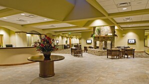 A spacious lobby with a reception desk, seating area, and a stone fireplace. - Wyndham Resort at Fairfield Mountains (Lake Lure)