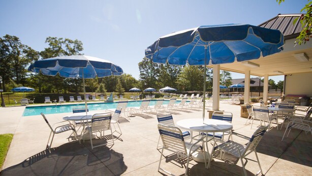 A poolside area with lounge chairs and umbrellas, a pool, and a covered seating area. - Wyndham Resort at Fairfield Mountains (Lake Lure)