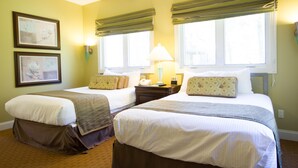 A hotel room with two beds, a nightstand, a lamp, and two framed pictures on the wall. - Wyndham Resort at Fairfield Mountains (Lake Lure)