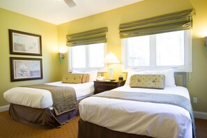 A hotel room with two beds, a nightstand, a lamp, and two framed pictures on the wall. - Wyndham Resort at Fairfield Mountains (Lake Lure)
