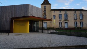 Un bâtiment doté d’une entrée moderne et d’une tour de style traditionnel.