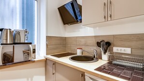 A modern kitchen with a microwave, kettle, and sink. - Le Vintage – Romantic Studio on Seine, Paris 6th (Paris)