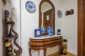A wooden console table with decorative items, a mirror, and a sign indicating a 9.4 rating.