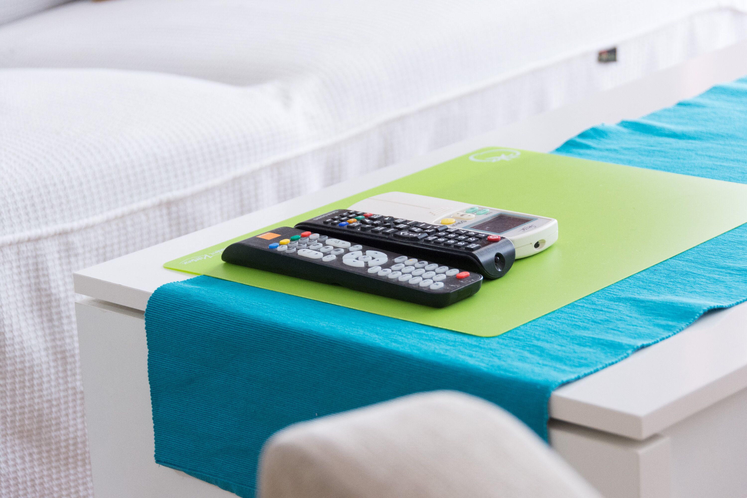 Un lit avec un matelas vert et deux télécommandes dessus.