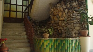 A staircase with a stone wall and potted plants. - Hotel Pomelo House (Kathmandu)