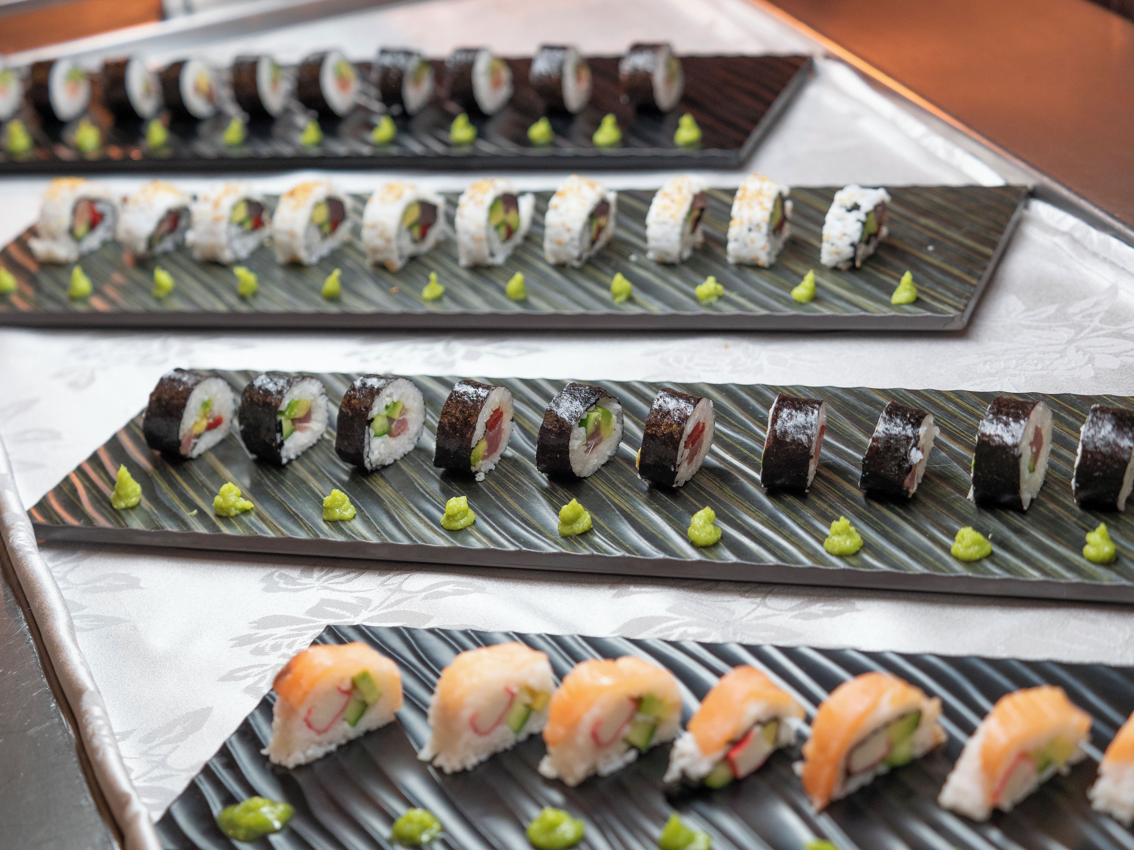 Sushi auf Tellern mit dekorativem Muster angeordnet.