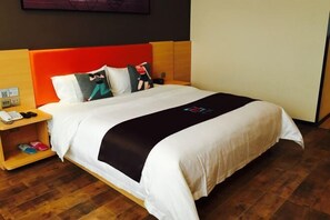 Ein Hotelzimmer mit Bett, Nachttisch und Holzboden.