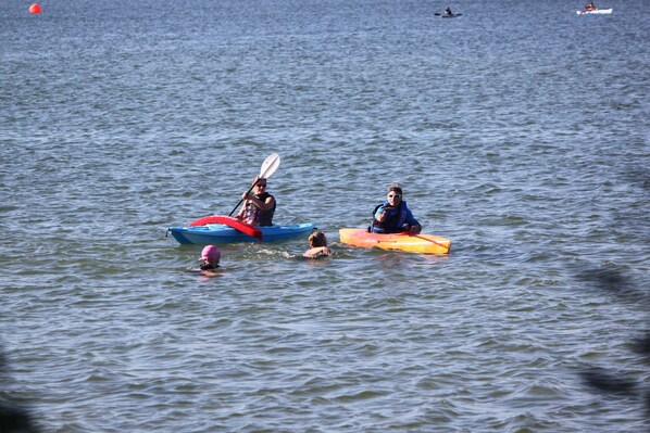 Une étendue d’eau calme où l’on peut faire du kayak et où une personne nage.