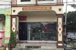 The entrance to TI Geok Chian Trading SDN. Bhd. with a glass door and a sign above it. - Hotel Hong (Melaka)
