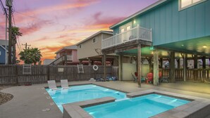 A backyard with two swimming pools, a wooden deck, and a house with a balcony. - Boogie Board! Pet Friendly! Private Pool (Port Aransas)