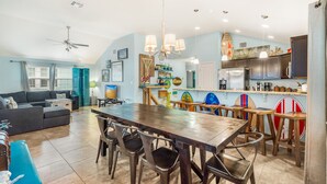 A spacious living area with a dining table, chairs, a sofa, and a ceiling fan. - Boogie Board! Pet Friendly! Private Pool (Port Aransas)