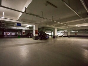 Un parking à plusieurs niveaux où sont stationnées plusieurs voitures.