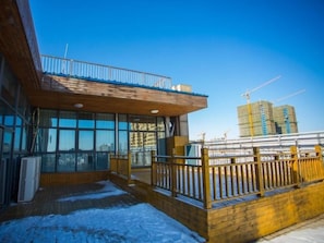 A modern building with large windows, a wooden deck, and a balcony. - Greentree Eastern Fuyang Yingdong District South (Fuyang)