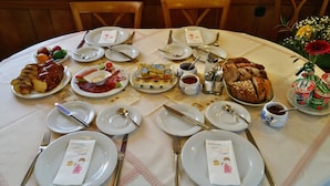 A breakfast setting with various dishes, utensils, and a tablecloth.