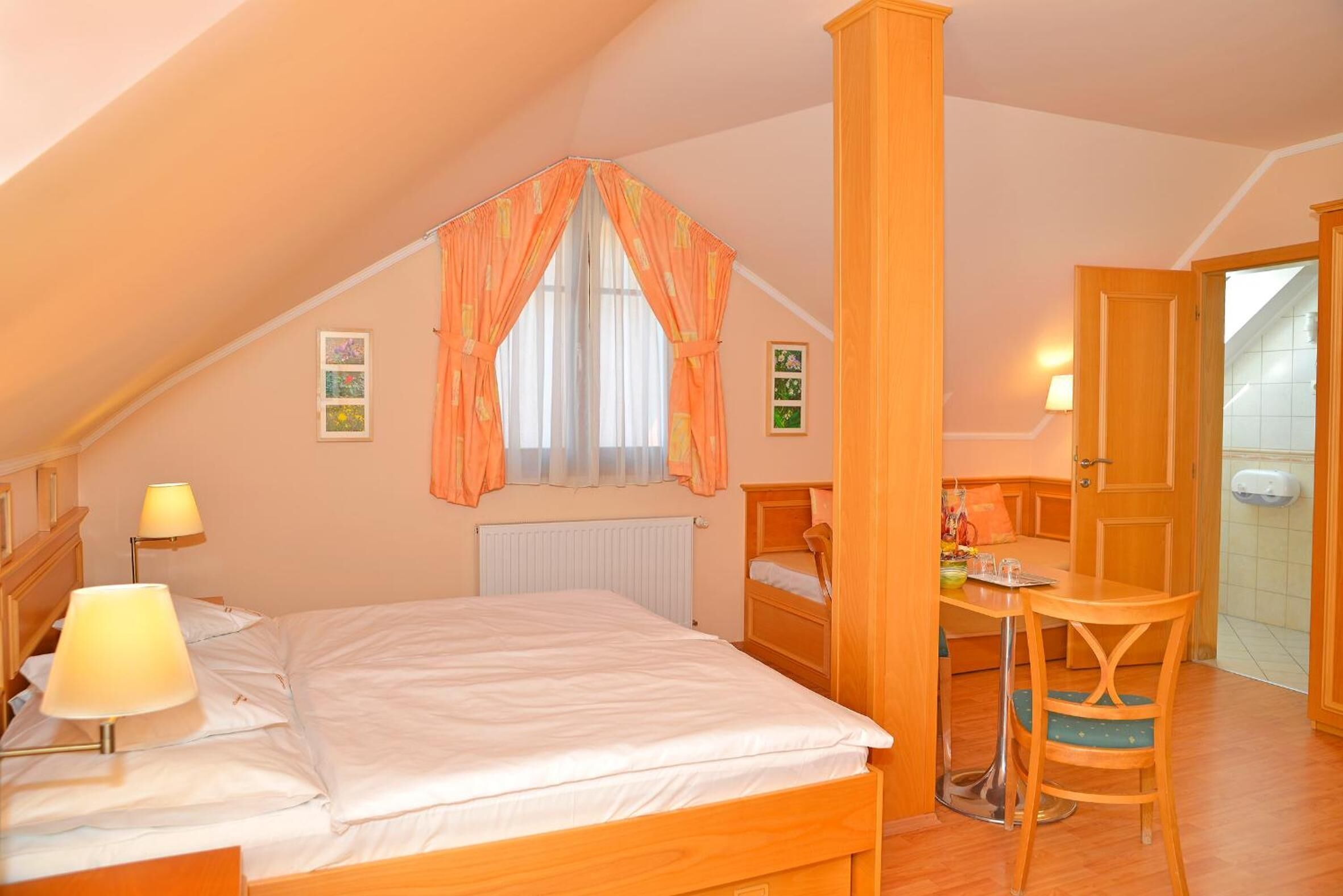 A bedroom with a single bed, a desk, and a chair.