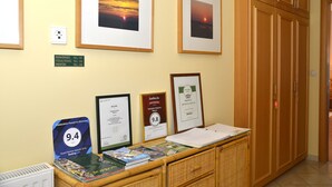 A reception area with framed pictures, a signboard, and a desk with brochures.