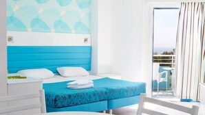 A hotel room with a bed, a table, and a balcony with a view. - Lantiana Gardens (Paralimni)
