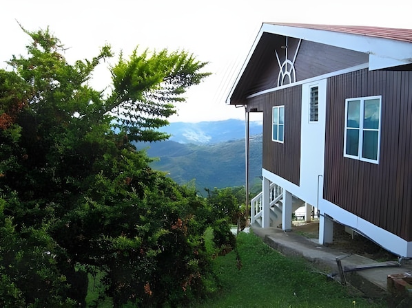 A modern two-story house with a view of mountains.