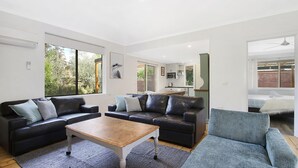 A modern living room with two sofas, a coffee table, and a view of the backyard. - Cobden & Wills - In the heart of Bright (Bright)