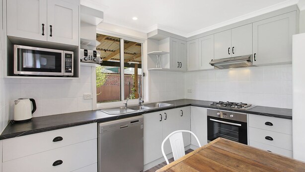 A modern kitchen with white cabinets, a microwave, a stove, and a dishwasher. - Cobden & Wills - In the heart of Bright (Bright)