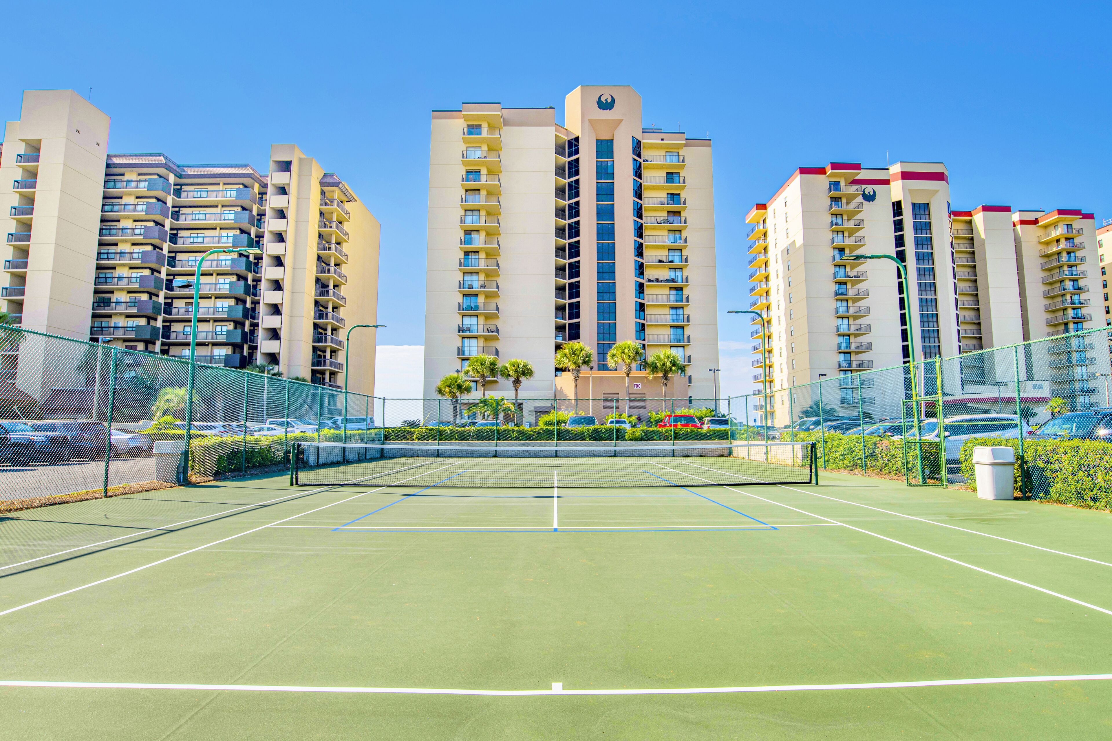 Un court de tennis entouré d’immeubles de grande hauteur.