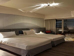 A modern hotel room with a large bed, a desk, and a chair. - Metro Hotel (Yunlin)