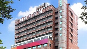 A multi-story hotel with a prominent red and white facade, multiple balconies, and a McDonald's restaurant at the ground level. - Metro Hotel (Yunlin)