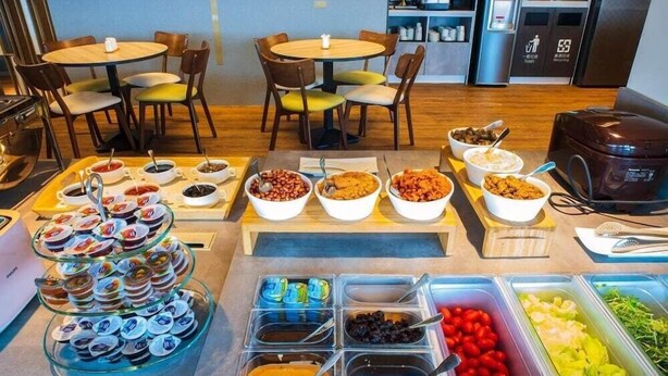 A breakfast buffet with various food options and seating areas. - Metro Hotel (Yunlin)