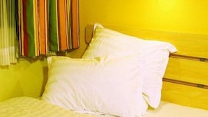 A bed with white bedding, a wooden headboard, and a yellow wall. - 7days Inn Hotel (Xinzhou)