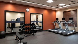 A gym with treadmills, dumbbells, a bench, and a mirrored wall. - Hampton Inn & Suites Buena Park (Buena Park)