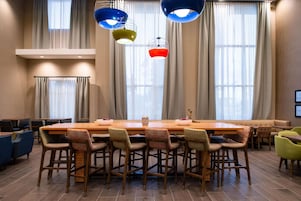 Un salón de conferencias con una mesa larga, varias sillas e iluminación colgante.