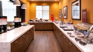 A modern kitchen with marble countertops, stainless steel appliances, and a buffet setup. - Hampton Inn & Suites Buena Park (Buena Park)