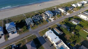 An aerial view of a coastal residential area with houses, a beach, and a road. - "Shore Beats Work" - 2nd Row Condo w/ Community Pool, 4 Bedrooms / 2 Bathrooms (Holden Beach)