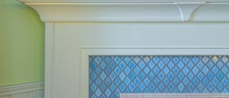 A fireplace with a tiled surround and a television mounted above it.