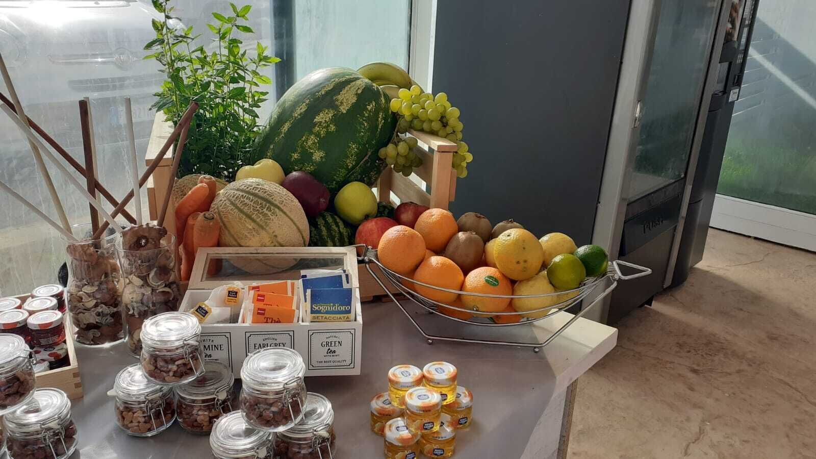 Una mesa con diversos alimentos, como frutas, tarros de conservas y productos envasados.