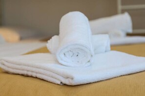 A stack of white towels on a wooden surface. - Mamire Tsg (Ugento)