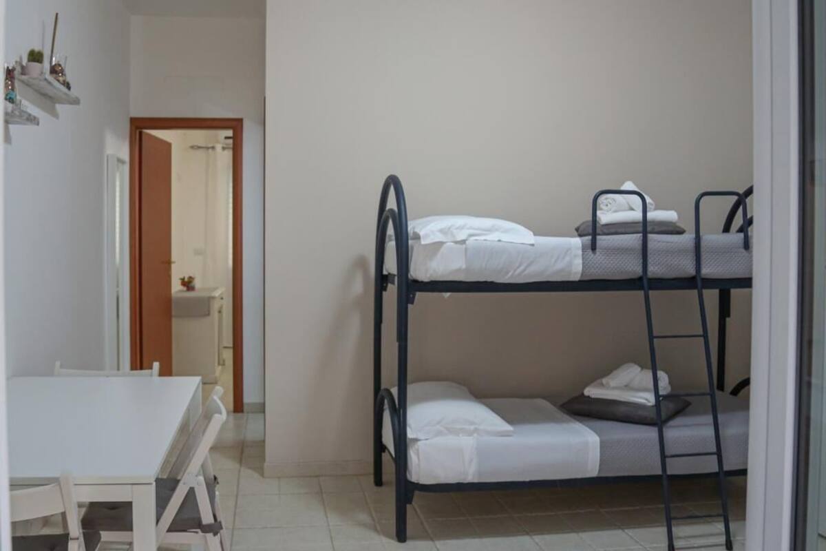 A bunk bed room with a table and a mirror.